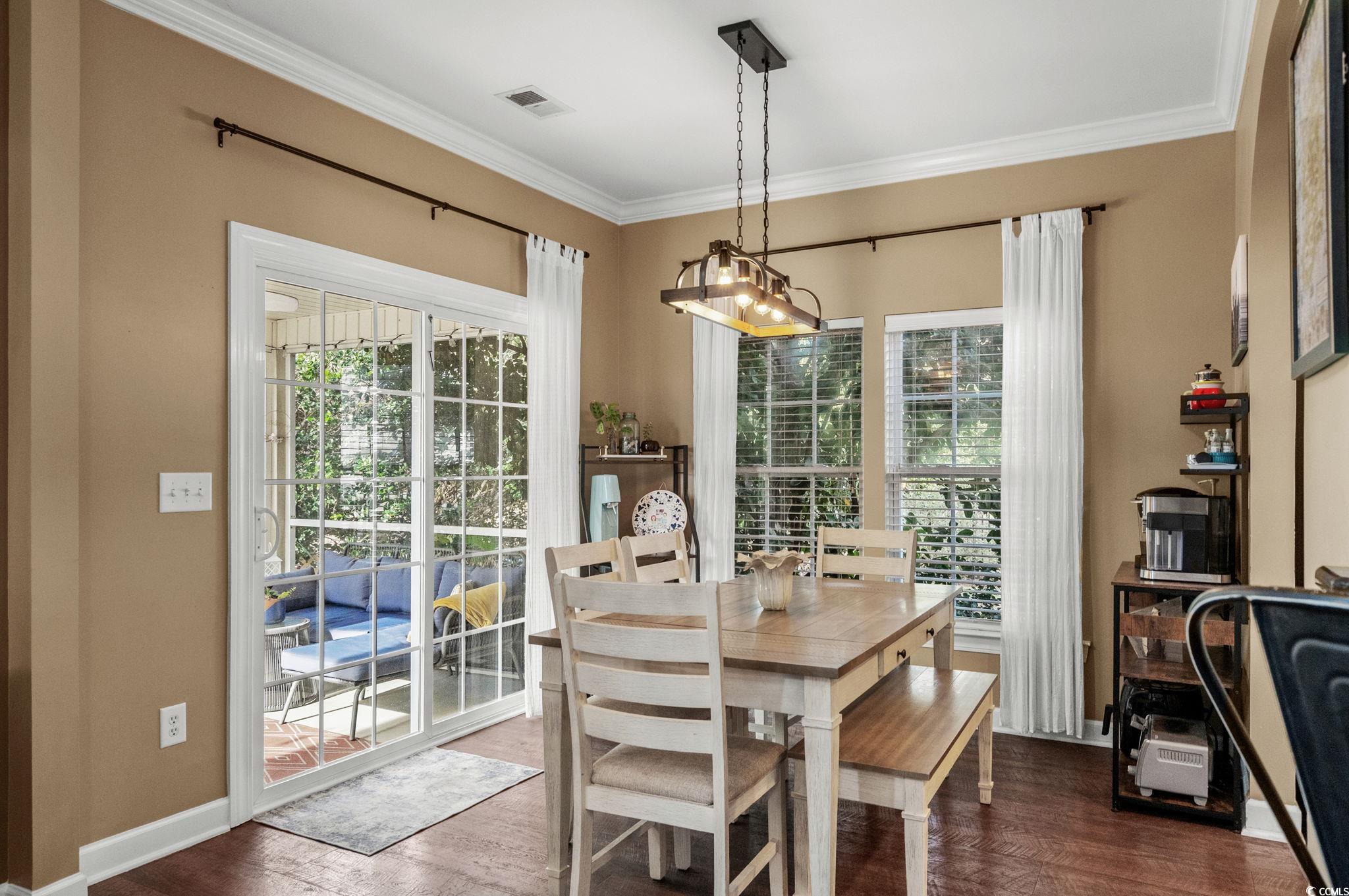 318 Barlow Court Conway, SC 29526 - Photo 9 of 36 Dining area with a chandelier, dark wood-style flooring, and crown molding