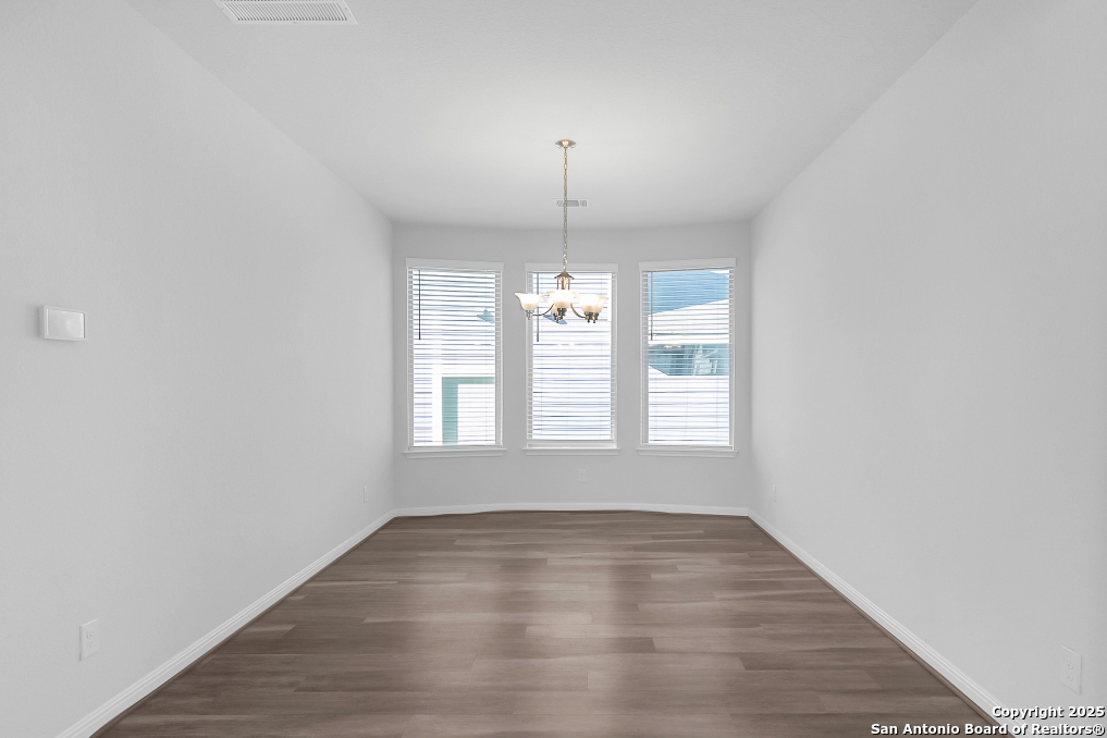 13223 Prospector Way St. Hedwig, TX 78152 - Photo 11 of 30 a view of an empty room with wooden floor and a window