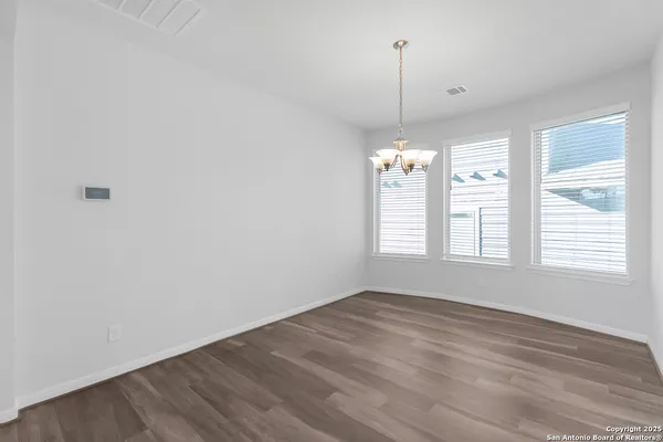 a view of a room with wooden floor ceiling fan and window