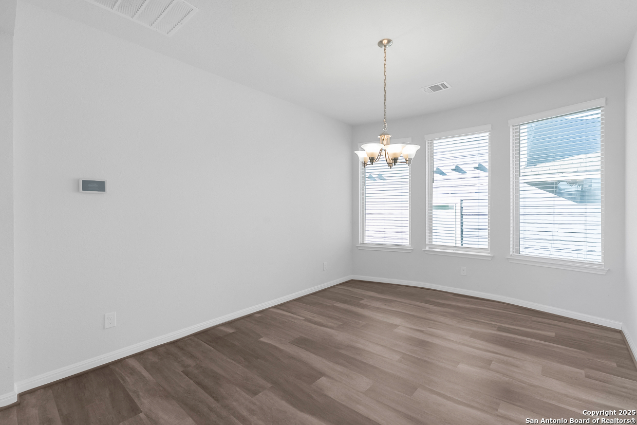 13223 Prospector Way St. Hedwig, TX 78152 - Photo 12 of 30 a view of a room with wooden floor ceiling fan and window