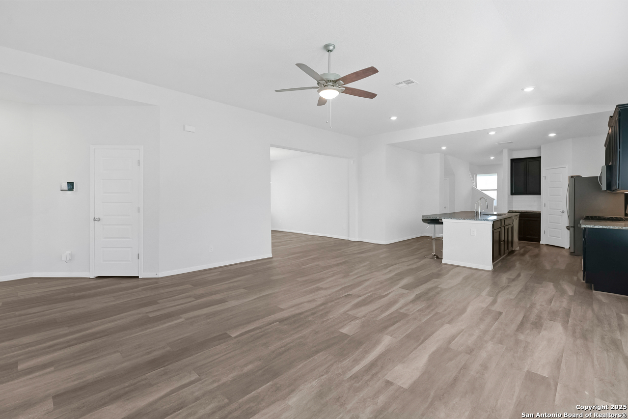 13223 Prospector Way St. Hedwig, TX 78152 - Photo 9 of 30 a view of kitchen with refrigerator microwave and wooden floor