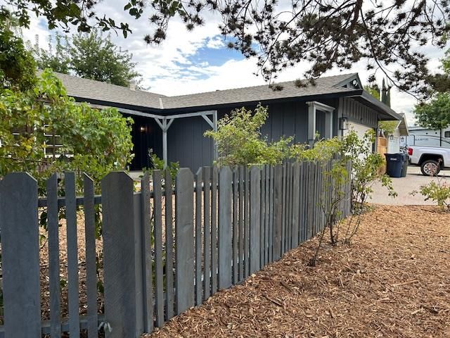 a view of a house with a wooden fence