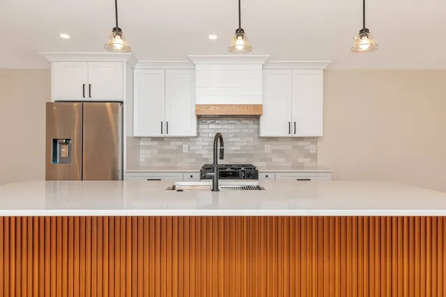 a kitchen with stainless steel appliances granite countertop a sink refrigerator and cabinets