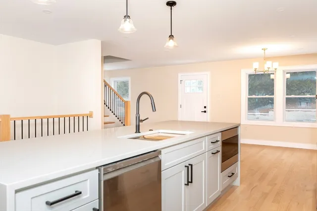 a kitchen that has a lot of cabinets and wooden floor