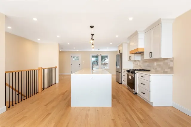 a large kitchen with stainless steel appliances granite countertop a large center island and a stove top oven