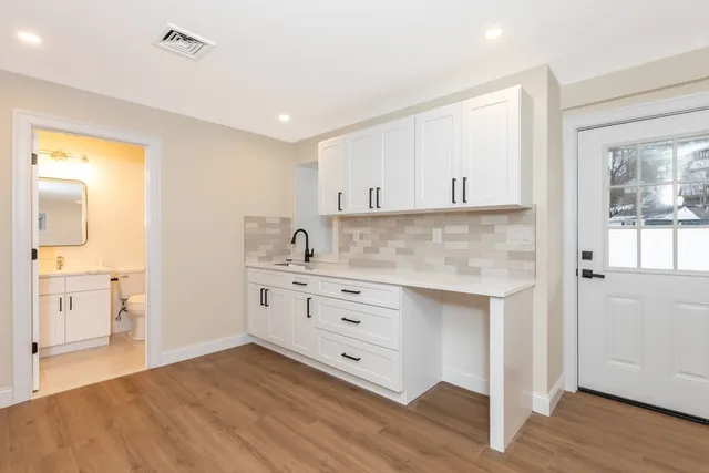 a kitchen with granite countertop white cabinets and white appliances