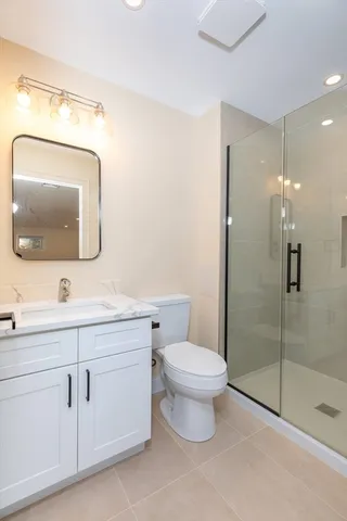 a bathroom with a toilet sink vanity and mirror