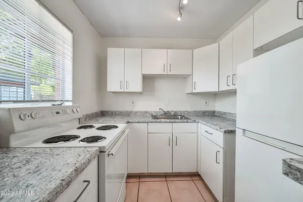 a kitchen with a sink a stove and cabinets