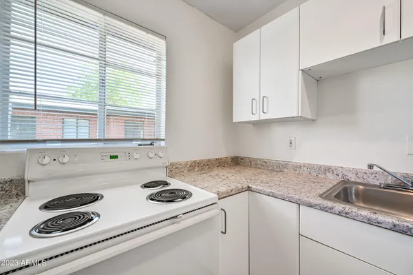a kitchen with a sink stove and white cabinets