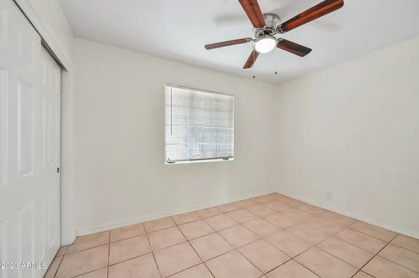 an empty room with a window and a fan