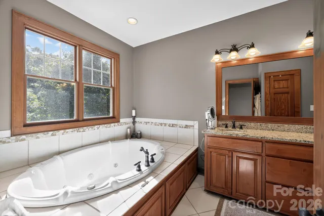 a bathroom with a tub sink and mirror