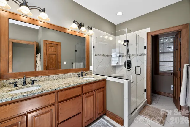 a spacious bathroom with a granite countertop sink mirror and shower