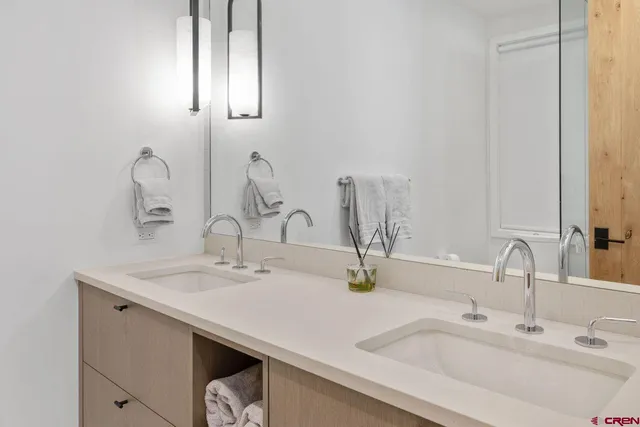 a bathroom with double vanity sinks and a mirror
