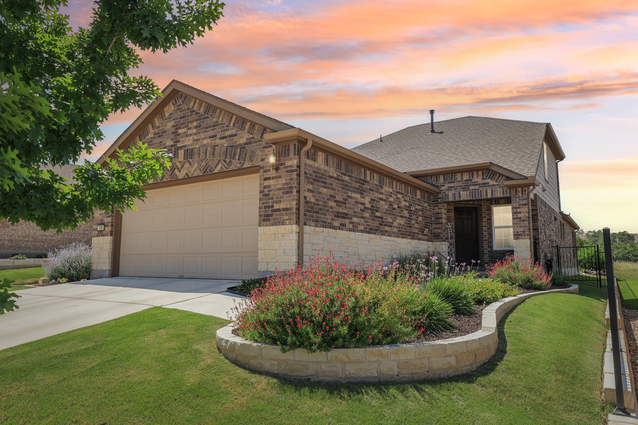 709 Kitty Hawk Road Georgetown, TX 78633 - Photo 1 of 1 View of front of home with an attached garage, driveway, stone siding, brick siding, and a shingled roof