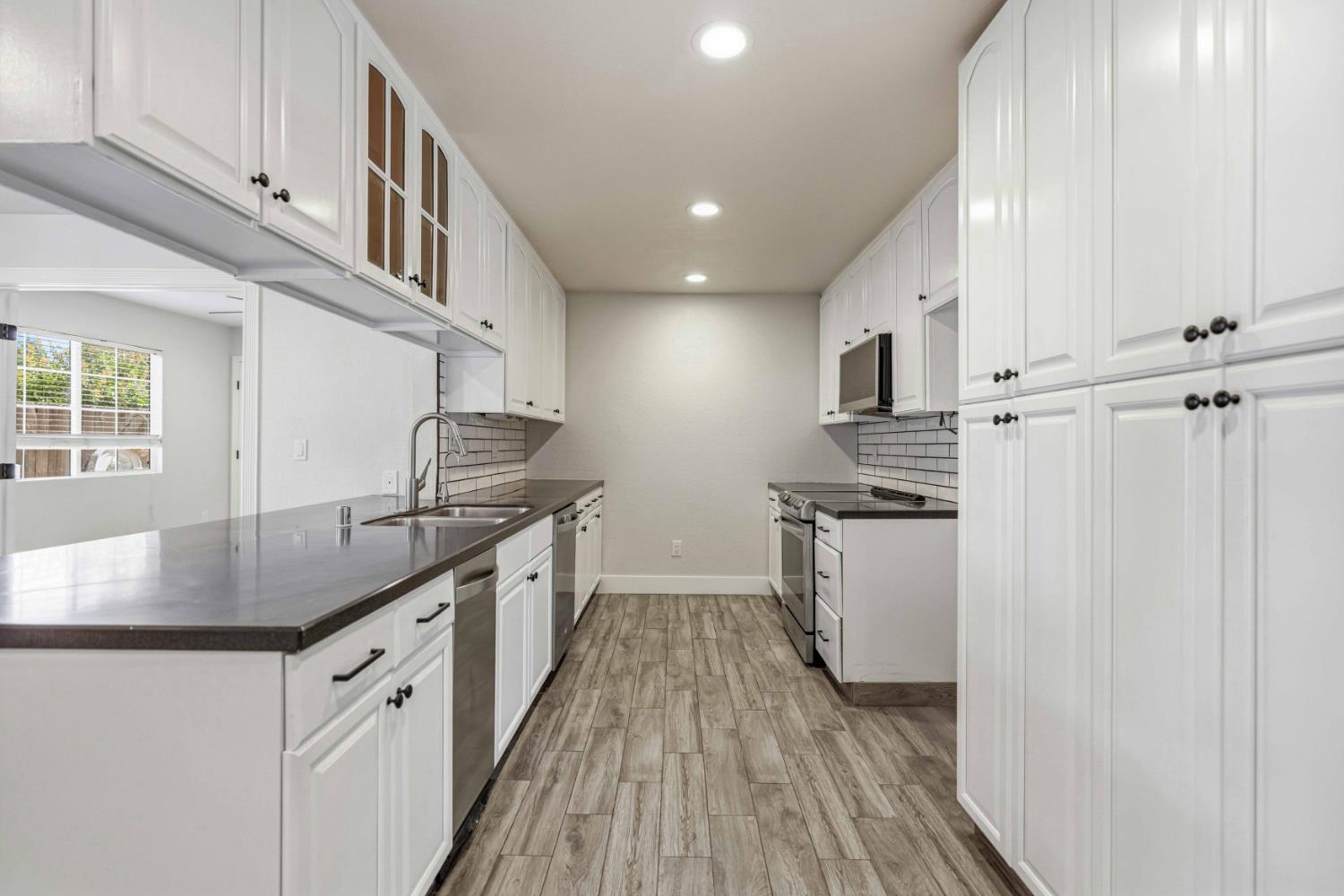 1464 Denise Drive Ripon, CA 95366 - Photo 8 of 41 a kitchen with stainless steel appliances granite countertop a sink stove and refrigerator