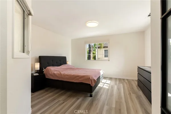 a bedroom with a bed and wooden floor