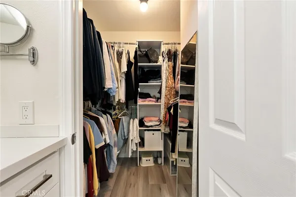 a view of walk in closet with clothes and shoes