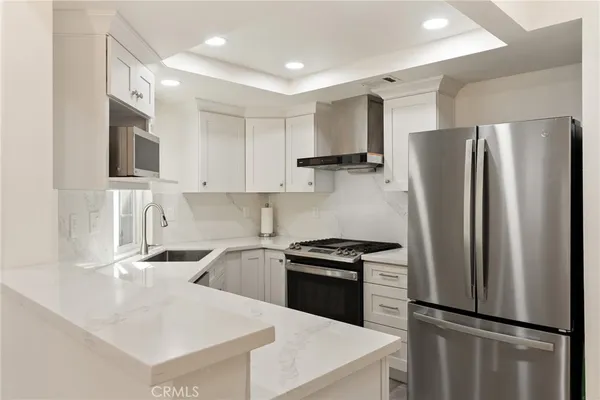a kitchen with a refrigerator sink and white cabinets