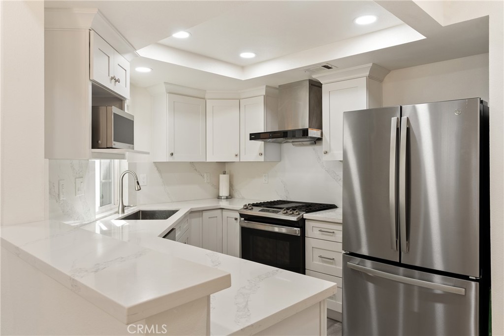 24 Rue De Nicole Lake Forest, CA 92610 - Photo 7 of 24 a kitchen with a refrigerator sink and white cabinets