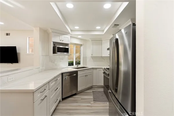 a kitchen with stainless steel appliances granite countertop a refrigerator and a sink