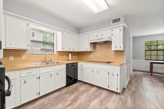 a kitchen with granite countertop white cabinets and white appliances