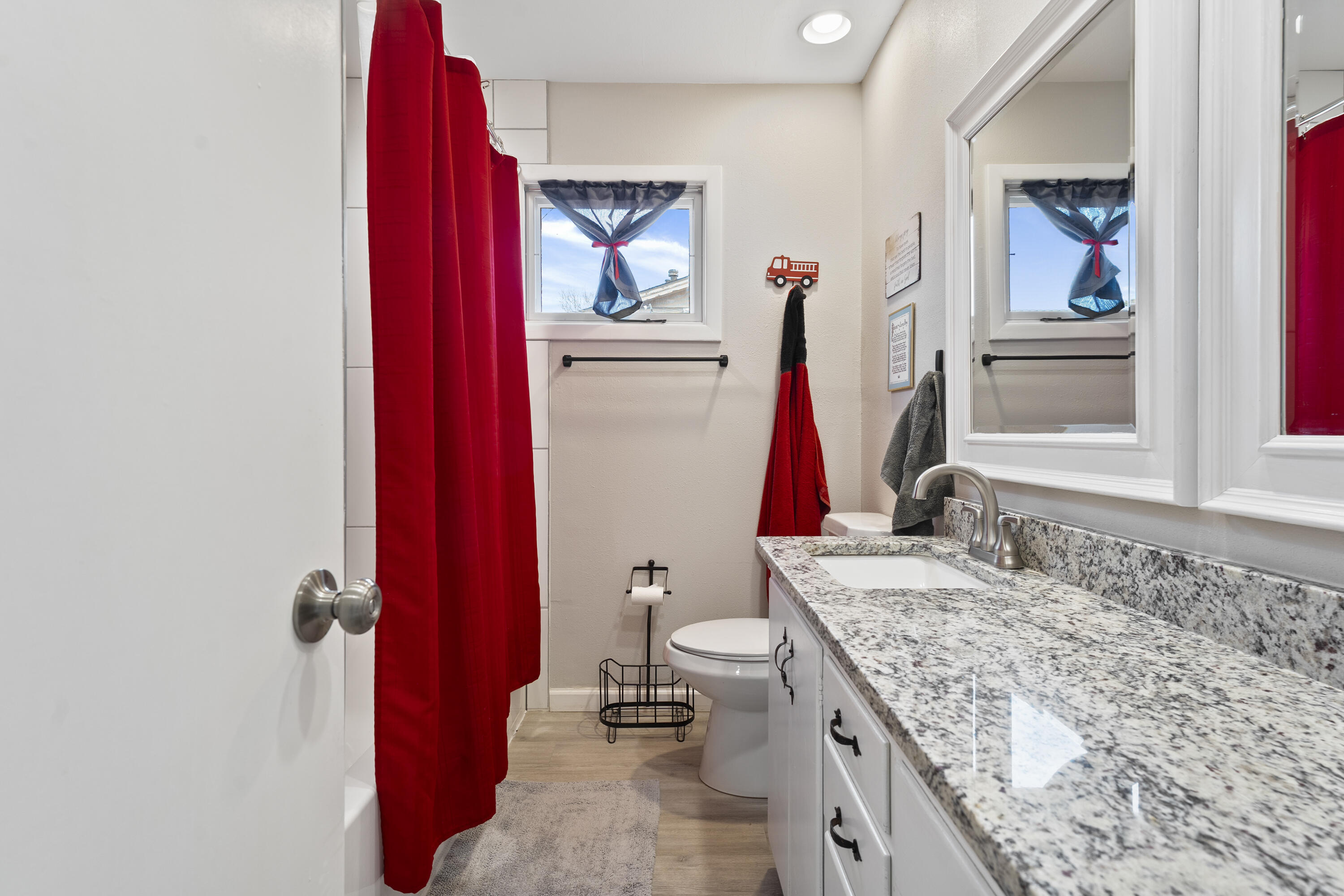 3703 41st Street Lubbock, TX 79413 - Photo 8 of 21 a bathroom with a granite countertop sink a toilet and a shower curtain