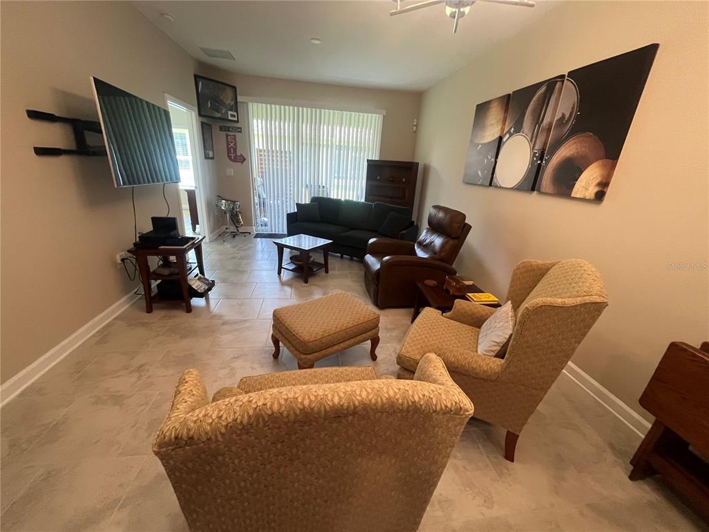 1064 Blackwolf Run Road Davenport, FL 33896 - Photo 18 of 38 a living room with furniture and a flat screen tv