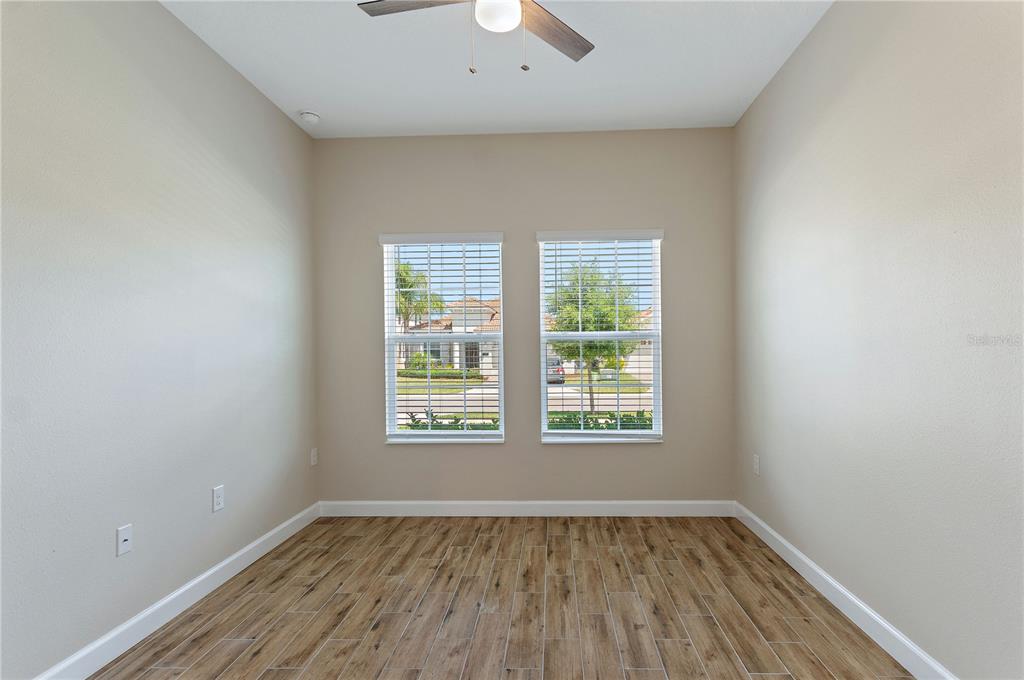 1064 Blackwolf Run Road Davenport, FL 33896 - Photo 8 of 38 an empty room with wooden floor and windows