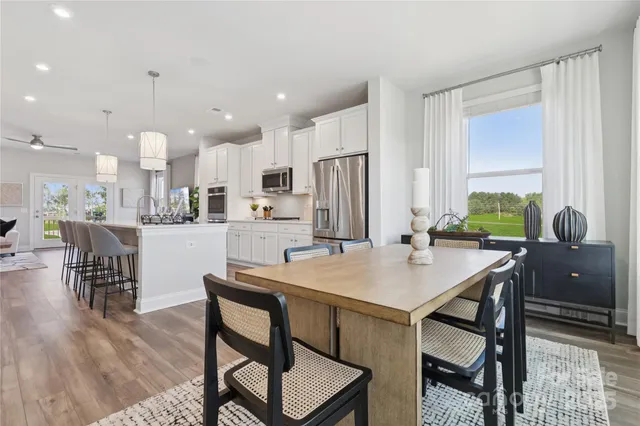 a kitchen with a table chairs refrigerator and cabinets
