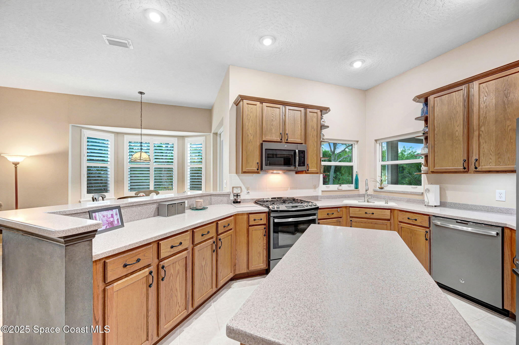 1692 Long Pine Road Melbourne, FL 32940 - Photo 14 of 43 a large kitchen with stainless steel appliances granite countertop a sink stove and refrigerator