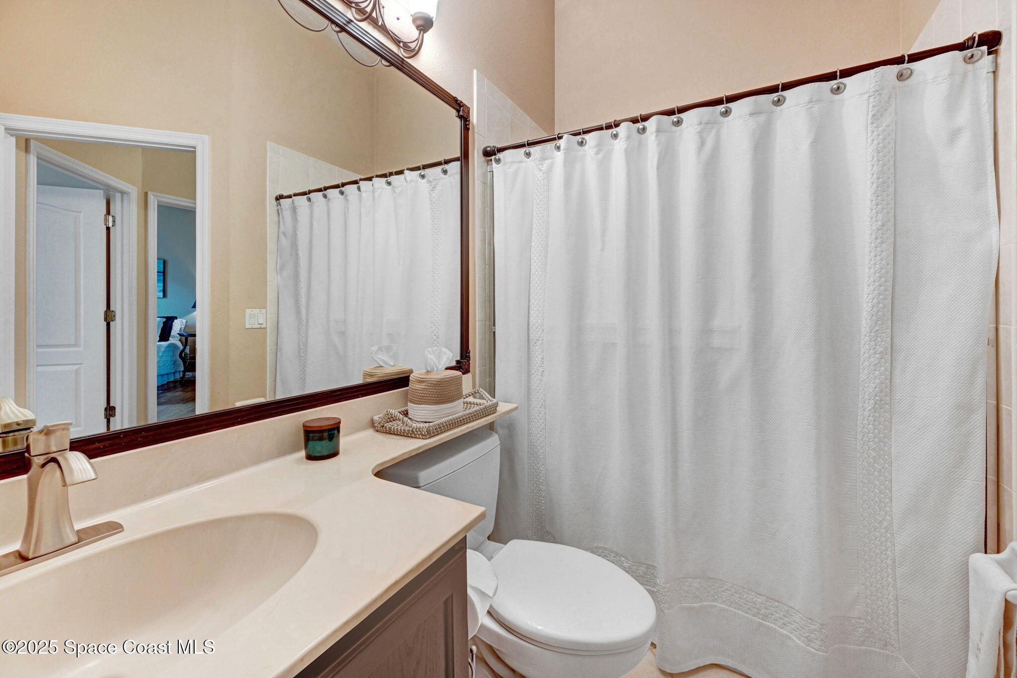 1692 Long Pine Road Melbourne, FL 32940 - Photo 30 of 43 a bathroom with a sink a toilet and shower curtain