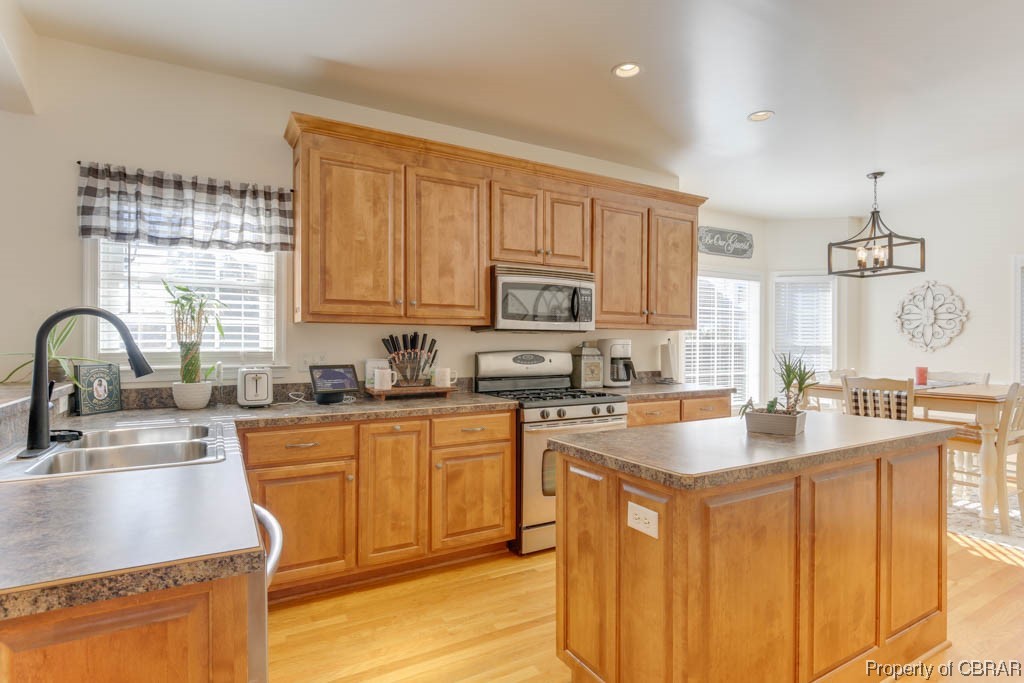 4 Willow Road Hampton, VA 23664 - Photo 22 of 48 Kitchen featuring light hardwood / wood-style floors, gas range oven, a chandelier, a wealth of natural light, and decorative light fixtures