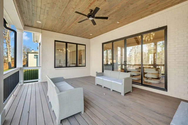 a large kitchen with stainless steel appliances kitchen island granite countertop a stove a sink a refrigerator and white cabinets with wooden floor