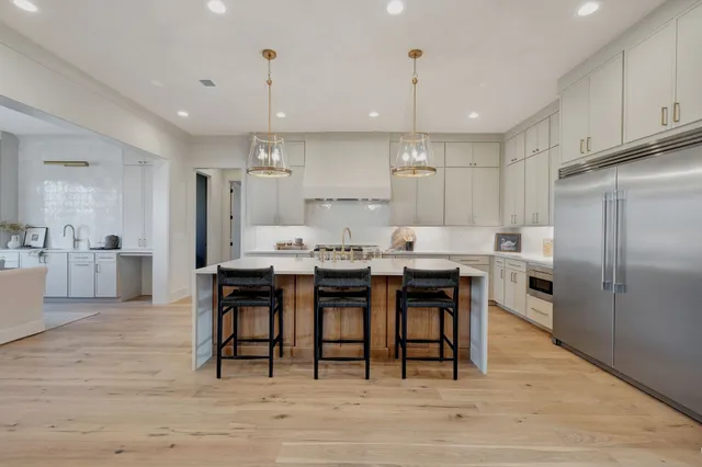 a dining hall with granite countertop a stove a sink a dining table and chairs