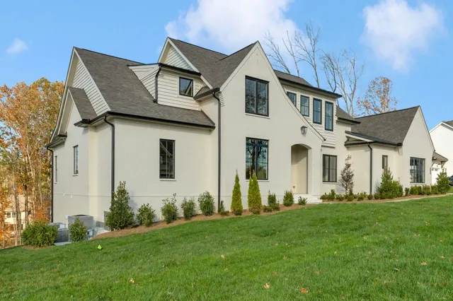 a front view of a house with a garden and plants