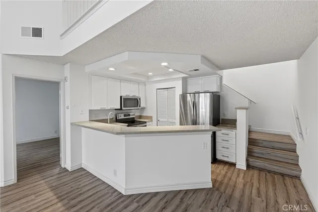 a kitchen with kitchen island a refrigerator stove and microwave