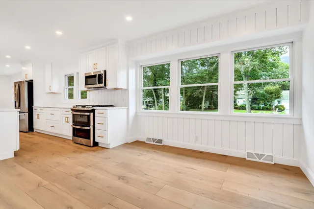 a view of empty room with wooden floor and fireplace