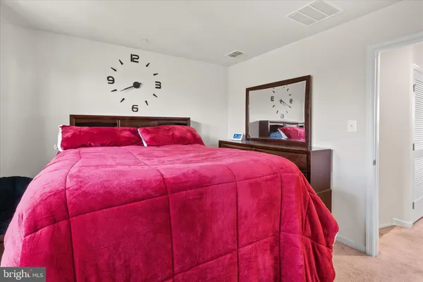 a bedroom with a bed and painting on the wall