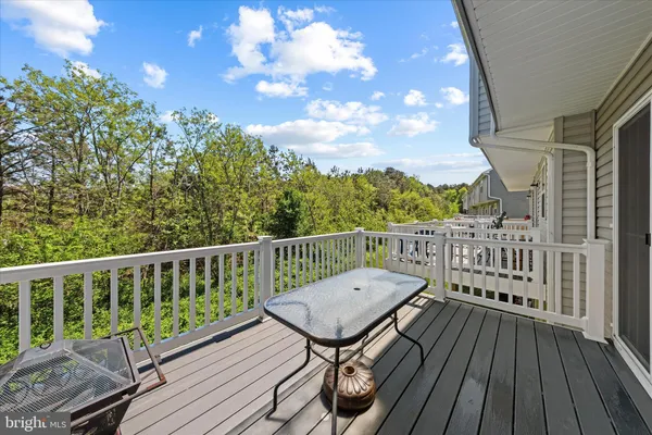 a view of a balcony with wooden floor and fence