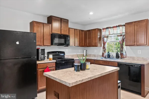 a kitchen with a sink a refrigerator and cabinets
