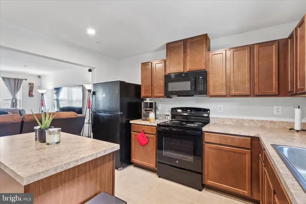 a kitchen with stainless steel appliances granite countertop a refrigerator stove top oven a sink and dishwasher