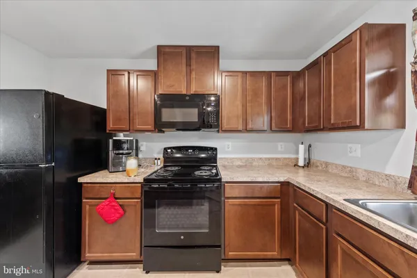 a kitchen with stainless steel appliances granite countertop a refrigerator stove and sink