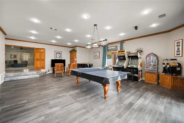 a living room with furniture a pool table and a fireplace