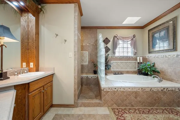 a spacious bathroom with a granite countertop sink a mirror and a shower