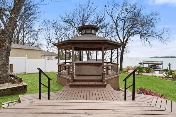 a view of a deck with table and chairs a barbeque with wooden fence and floor