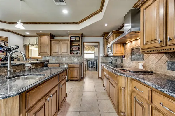 a large kitchen with stainless steel appliances granite countertop a sink stove and cabinets