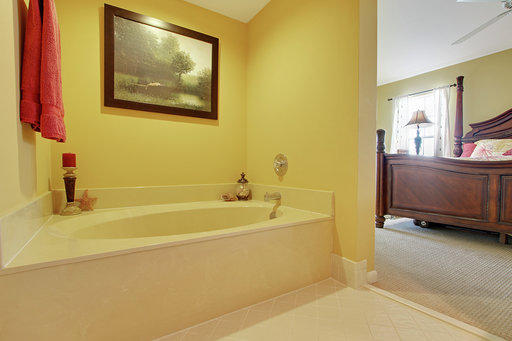 814 Ocean Dunes Circle Jupiter, FL 33477 - Photo 18 of 34 a bathroom with a tub sink and mirror