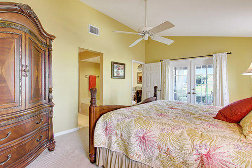 814 Ocean Dunes Circle Jupiter, FL 33477 - Photo 20 of 34 a bedroom with a bed and a chandelier