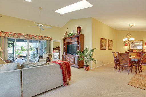 814 Ocean Dunes Circle Jupiter, FL 33477 - Photo 23 of 34 a living room with furniture a chandelier and a flat screen tv