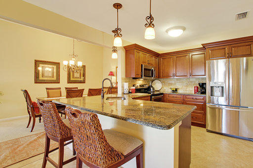 814 Ocean Dunes Circle Jupiter, FL 33477 - Photo 10 of 34 a kitchen with granite countertop a table chairs stove and refrigerator